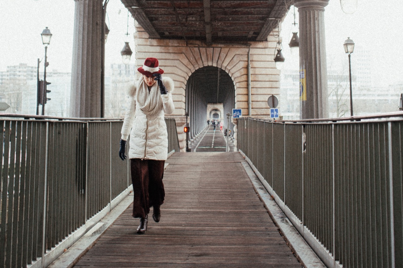 A person standing on a covered walkway overlooking the water